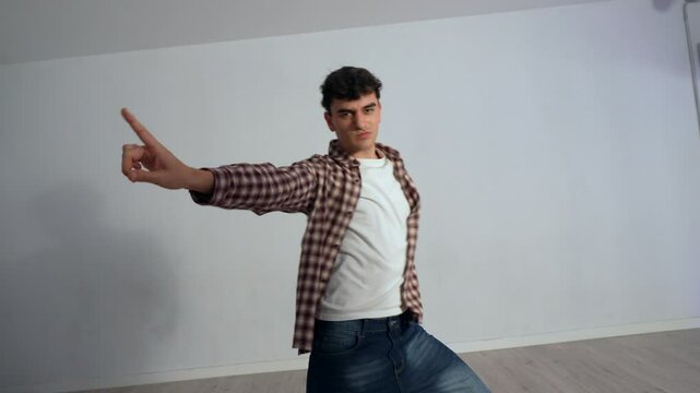 Professional male dancer practicing dynamic contemporary dance movements in minimalist urban dance studio, exploring artistic expression through fluid choreography