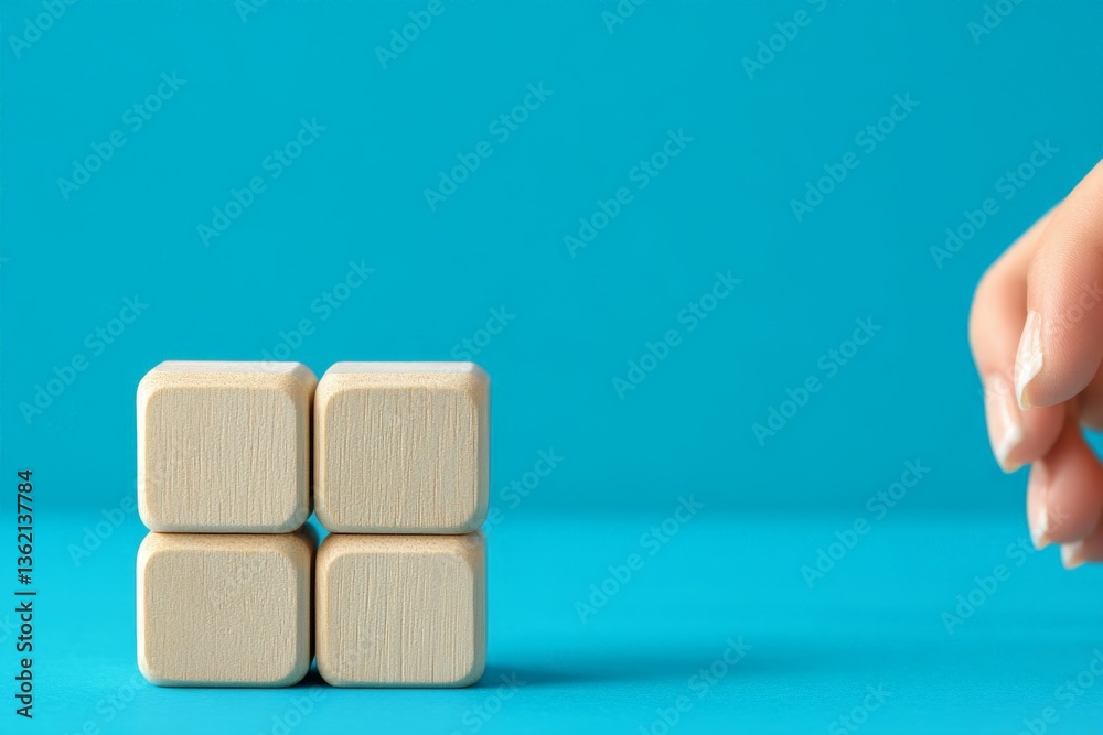 Poster wooden blocks are arranged on a vibrant blue background by a hand for a creative activity or educati