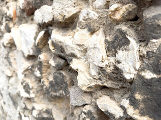 Close-up of rough textured stone wall with natural colors and patterns