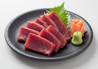 Sliced Tuna Sashimi on Dark Plate with Wasabi and Ginger