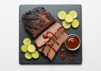 Smoked Brisket Slices with Pickles and BBQ Sauce on Dark Slate Plate