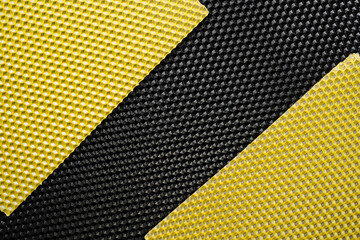 Yellow and black natural beeswax sheets textured background, flat lay.