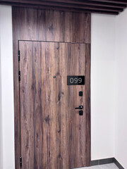 Modern wooden door with apartment number.