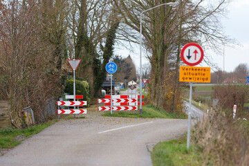 Road closure with traffic signs and barriers in a rural area during autumn