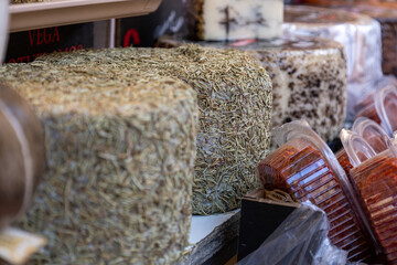 Artisanal Cheese Covered in Herbs at a Market Stall