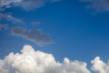 Fluffy White Clouds and Dark Shadows in a Blue Sky