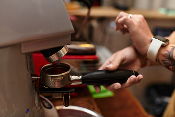 Coffee preparation by a young woman in a cozy cafe setting during afternoon hours