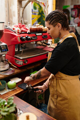 Young woman expertly prepares coffee at a vibrant cafe showcasing her talent and passion