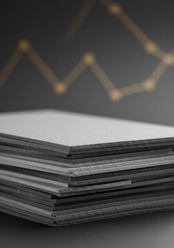 Stack of gray textured papers against gold graph background. AI Generated