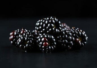 A high-resolution, advertising-style shot of blackberries in an elegant arrangement, their glossy surface reflecting light, on a solid white background.