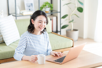 リビングでパソコンを使う若い女性