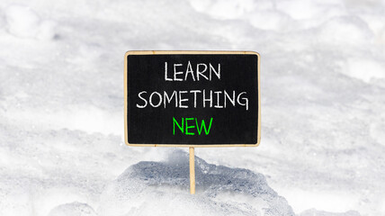 Learn something new symbol. Concept words Learn something new on beautiful blackboard. Beautiful white snow background. Business motivational lifestyle learn something new concept. Copy space
