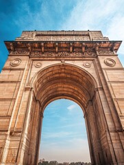 Obraz premium Close-up of India Gate's intricate engravings and architecture under a bright blue sky, ideal for historical themes, with copy space