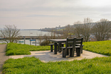 Recreation area in the park, a wooden bench with a table stands on a hill overlooking the sea