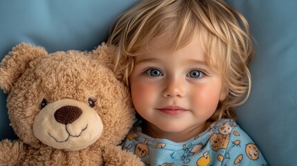 A blond toddler snuggles a brown teddy bear. Warm, soft, serene, with a blanket