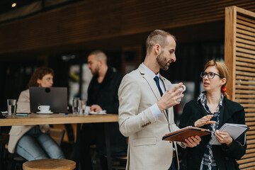 Group of business professionals discussing ideas and working together outdoors in a casual setting. Concepts include teamwork, collaboration, creativity, and professional networking.