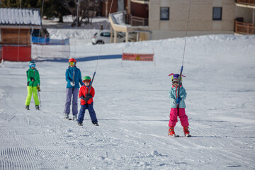 Ski lift carries skiers up the snowy winter mountain on resort