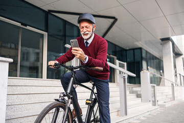 Senior Businessman Using Phone and Bike in Urban Setting
