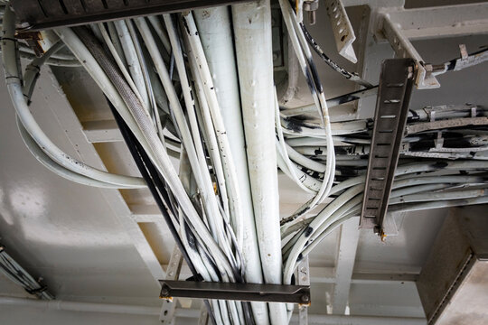 Electrical cables running along the ceiling of a ferry cabin ceiling, the wiring on a ferry.