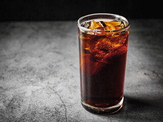 Cola soft drink with ice cubes, soda pop fizzy drink in Cold glass on gray background