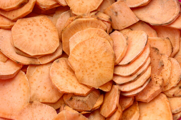orange texture and background on raw sweet potato cut into small pieces