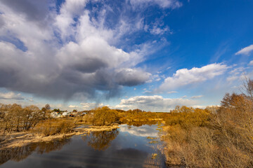 A cloudy sky with a river in the foreground