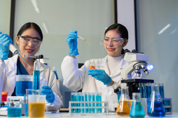 Fototapeta premium Scientist analyzing and dropping a sample into a glassware.