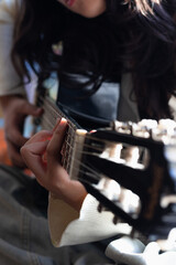 the fingers of a girl practicing guitar