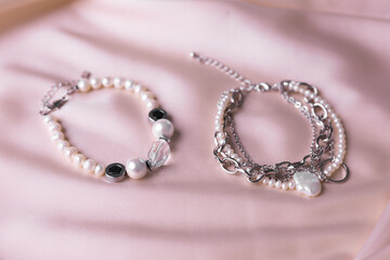 Jewelry on satin fabric with pearl bracelets and wheat elements. Handmade bijouterie And natural aesthetics in fashion