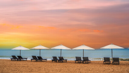Panoramic Scenic view of the sandy beach with umbrellas and sun beds on the coastline.