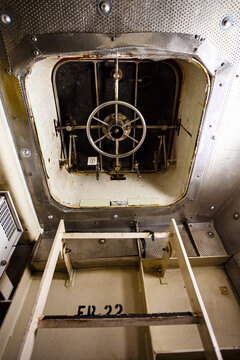 Interior door on a boat, a ladder and a watertight door with a wheel locking mechanism.