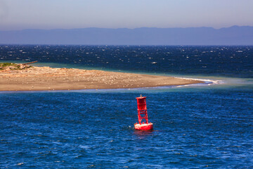 Starboard buoy in the sea off a sandspit at Ediz Hook Port Angeles.