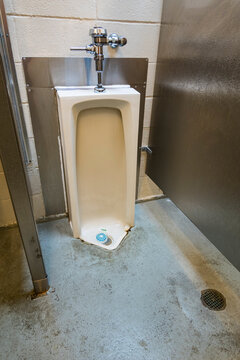 A public restroom urinal, a toilet at a reststop on a major road.