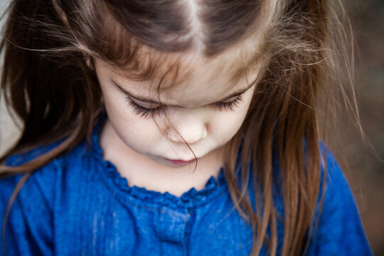 Little girl with pigtails looking down