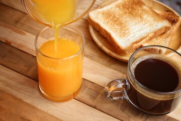 Breakfast of orange juice summer drink and black coffee  toast bread