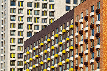 Modern city buildings with vivid window accents and repetitive geometry form a structured and...