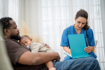 Fototapeta premium Doctor consulting with a father holding his sleeping baby in a bright, modern clinic during a routine checkup