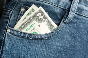 a two dollar bill sticking out of a jeans pocket