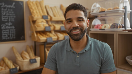 Young man smiling in bakery with shelves of bread and pastries in background