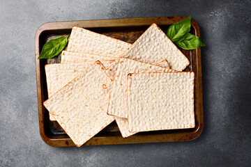 Matzoh jewish bread on a metal tray. Top view, on a gray background.