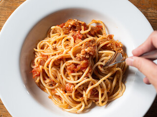 fork twirling spaghetti with tomato sauce