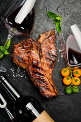 Bottled wine and Beef T-bone steak. Prime Black Angus beef steak and aged wine. Top view.