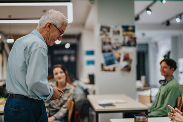 An elderly professor interacts warmly with attentive students in a classroom. The environment is...