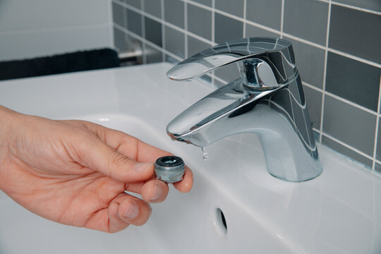 man have removed the aerator from a faucet