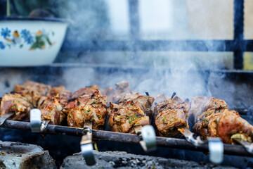 Barbecue on the grill. Grilled kebab cooking on metal skewer, close up 