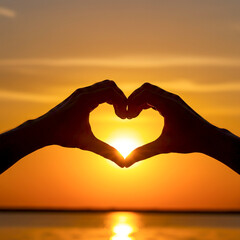 heart in hands against sunset