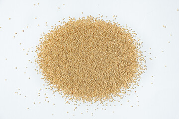 Pile of raw organic amaranth grains on a white background, top view