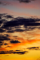 Obraz premium Sunset. Sky clouds in the Evening with Orange, Yellow Gold sunlight in the sunset. Dramatic dark clouds. Summer sky landscape, Dusk sky background