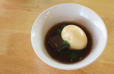 Braised eggs in a bowl on a wooden table