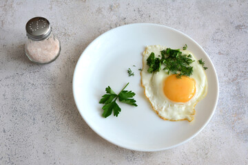 Fried egg with parsley and a side of salt